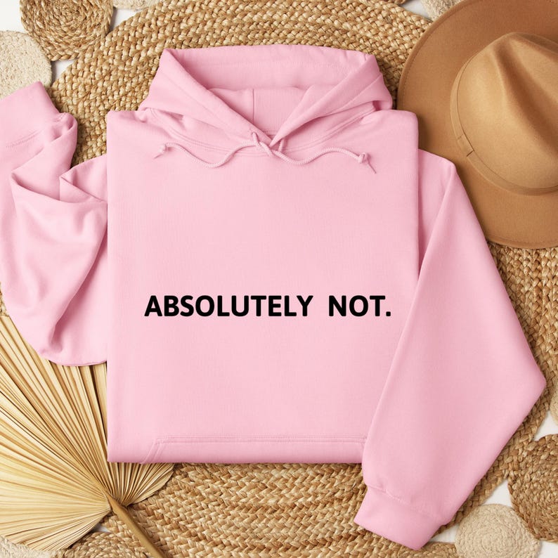 Op de afbeelding: Een roze hoodie met de tekst "ABSOLUTELY NOT." in zwart op de voorkant.