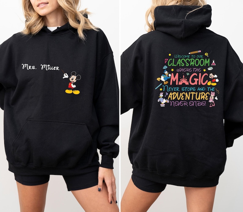 May include: Black hooded sweatshirt with a Mickey Mouse design on the front and a Disney-themed classroom quote on the back. The quote reads "Welcome to our classroom where the magic never stops and the adventure never ends!"