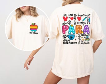 May include: Cream-colored t-shirt with a colorful apple graphic and the text "Mrs. Williams" on the front. The back of the shirt features the word "PARA" in large, colorful letters, surrounded by words like "Loving" and "Supportive".
