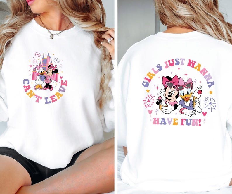 Puede incluir: Sudadera blanca con un gr&aacute;fico rosa y morado de Minnie Mouse y Daisy Duck. La parte delantera de la camiseta dice "Can't Leave" y la parte trasera dice "Girls Just Wanna Have Fun!"