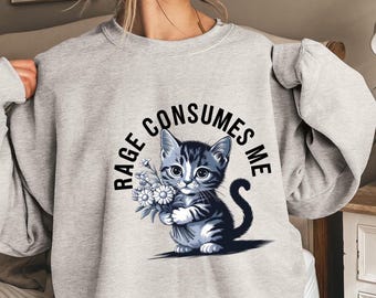 May include: Gray sweatshirt with a graphic of a cat holding flowers and the text "Rage Consumes Me".