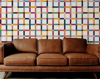 May include: A brown leather sofa with a mid-century modern design is positioned in front of a wall with a colorful grid pattern. The grid features squares in various colors, including red, yellow, blue, and green.