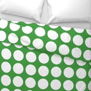 May include: Green bedding with a white polka dot pattern.