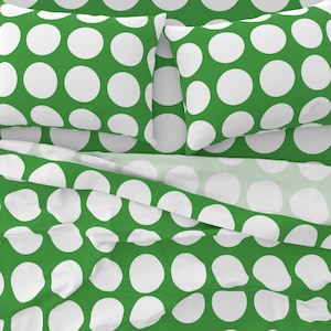 May include: Green and white polka dot bedding set with two pillowcases and a fitted sheet.
