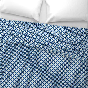 May include: A blue and white geometric patterned duvet cover with a white pillow on top.
