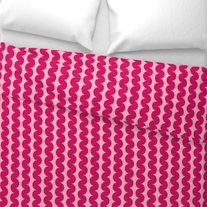 May include: Pink and red bedding with a repeating pattern of wavy circles.