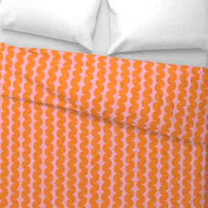 May include: A pink and orange bedding set with a repeating pattern of orange semi-circles.