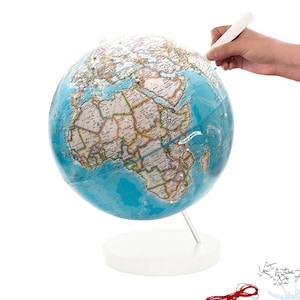 May include: A blue globe with a white stand and a white marker. The globe has a map of the world with country borders and names. The marker is being used to point to the country of Madagascar.