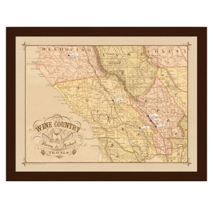 May include: A vintage-style map of California's wine country with pinpoints marking different wine regions. The map is framed in a brown frame and has the text "Wine Country" and "Sherry & Michael Travels" in a decorative font.