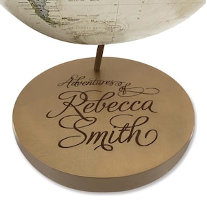 May include: A gold-colored globe base with the inscription "Adventures of Rebecca Smith" in a cursive font.