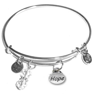 May include: A silver-toned expandable wire bangle bracelet featuring four dangling charms: a circular lotus flower pendant, two clear faceted crystal beads, a round charm engraved with the word Hope, and a small oval tag stamped Made in USA.