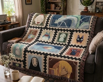 May include: A woven throw blanket featuring a grid of rectangular postage stamp designs. Each stamp displays a different animated character or scene in various colors, including a white dragon, a blue creature, a black spirit, and a blonde figure.