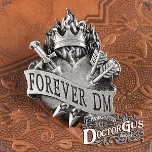 May include: A silver-toned metal pin featuring a heart with a crown, sword, and arrows. The heart is on fire and has a banner that reads "FOREVER DM". The pin is handcrafted by Doctor Gus.