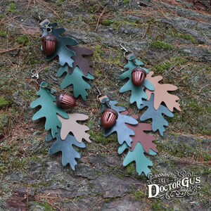 May include: Four leather acorn charms with oak leaf designs in shades of green, brown, and tan. Each charm features a small, detailed acorn with a metal loop for attaching to a keychain or bag.