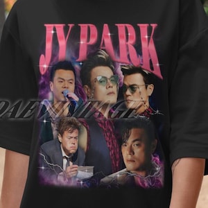 May include: Black t-shirt with a pink "JY PARK" graphic featuring a collage of five men. The men are wearing different outfits and have different hairstyles. The background is a dark purple and black galaxy print.