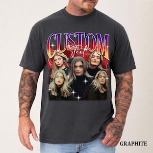 May include: Graphite-colored t-shirt featuring a graphic design with the word "CUSTOM Text" in a retro font. The design includes multiple images of a woman with long blonde hair. The word "GRAPHITE" is printed at the bottom.