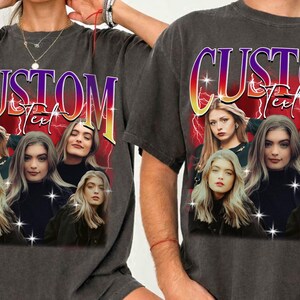 May include: Dark gray t-shirts featuring a graphic design with the word "CUSTOM Text" in a gradient font. The design includes multiple images of a woman with long blonde hair, set against a red background with lightning bolts.