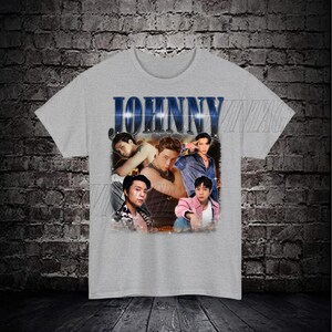 May include: Gray t-shirt with a vintage-style graphic featuring four men and the word "JOHNNY" in blue letters.
