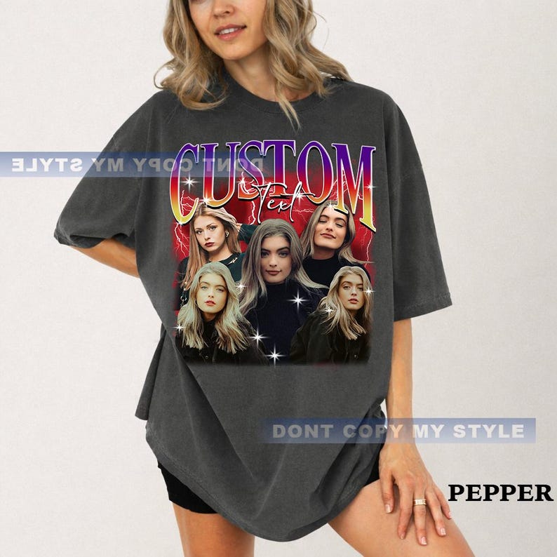 May include: Dark gray t-shirt featuring a graphic with the word "CUSTOM" in a colorful, retro font. The graphic includes images of five women. The text "DONT COPY MY STYLE" is printed on the shirt. The word "PEPPER" is also printed on the shirt.