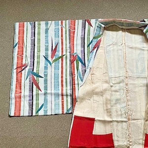 May include: A kimono with a bamboo pattern. The outer fabric features vertical stripes in red, green, blue, and purple, with bamboo stalks and leaves. The interior is cream-colored with red accents at the bottom.