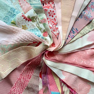 Puede incluir: Una colección de muestras de tela en varios tonos de rosa y verde con patrones florales y geométricos. La tela está dispuesta en un patrón circular, con los bordes de cada muestra superpuestos.