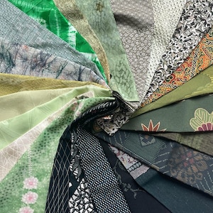 May include: A collection of fabric swatches in various shades of green, brown, and black. The fabrics have different patterns, including floral, geometric, and abstract designs.