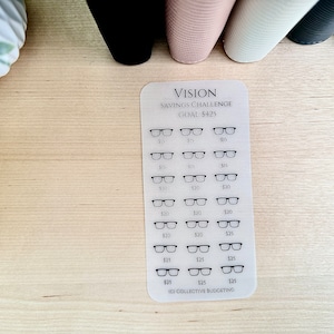 May include: A transparent sheet with a savings challenge tracker. The sheet has a title "VISION SAVINGS CHALLENGE GOAL: $425" and features a grid of eyeglasses with dollar amounts next to each pair. The amounts increase from $5 to $25. The bottom of the sheet reads "(C) COLLECTIVE BUDGETING".