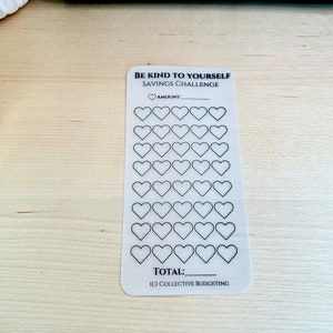 May include: A white printable savings challenge tracker with the text "Be Kind to Yourself Savings Challenge". The tracker has 35 heart-shaped boxes to fill in with a designated amount of money. The text "Amount" and "Total" are included on the tracker. The text "(c) Collective Budgeting" is at the bottom of the tracker.