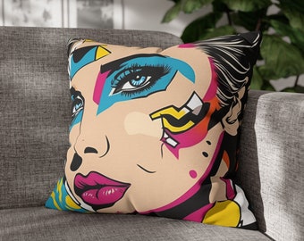 May include: A colorful throw pillow with a pop art style illustration of a woman's face with blue, pink, yellow, and black makeup. The background is black.