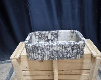 May include: A rectangular marble sink with a white and purple marbled pattern. The sink is sitting in a wooden crate.