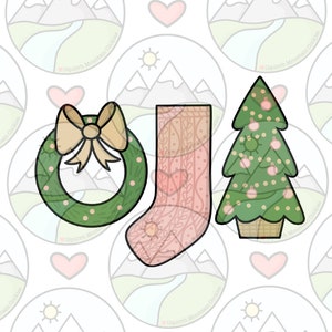 Puede incluir: Tres cortadores de galletas de Navidad: una corona con un lazo, una media y un árbol de Navidad con adornos. Los cortadores son verdes, rosas y marrones.