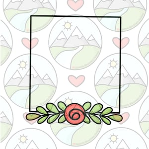 May include: A black frame with a floral design at the bottom. The floral design features a red rose with green leaves. The frame is on a white background with a repeating pattern of mountains and hearts.