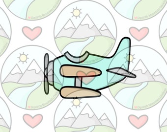 May include: A light blue airplane cookie cutter with brown propeller blades and a red heart on the front. The cookie cutter is surrounded by a repeating pattern of mountain range cookie cutters with a sun and a river.