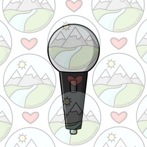May include: A black and white cookie cutter in the shape of a microphone with a mountain scene inside the microphone head. The mountain scene is a light green valley with a blue river and three gray mountains with white snow caps. The cookie cutter has a red heart on the side and the words "Oquirrh Mountain Cookies" are repeated around the image.