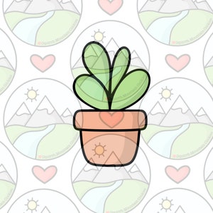 Puede incluir: Una planta verde en maceta con una maceta en forma de corazón y un sol en la parte delantera. La planta tiene tres hojas y está en una maceta marrón con un corazón blanco en la parte delantera.