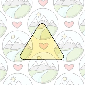 May include: A yellow triangle with a heart in the center. The triangle is surrounded by a pattern of white circles with a mountain range, a sun, and a river inside each circle. The text "Oquirrh Mountain Cookies" is written around the edge of each circle.