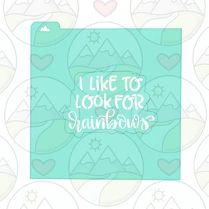 May include: A turquoise blue stencil with a mountain scene and the text "I like to look for rainbows".