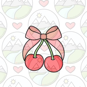 Puede incluir: Un cortador de galletas con forma de dos cerezas con un lazo. Las cerezas son rojas con tallos verdes, y el lazo es rosa. El fondo es un patrón repetitivo de ilustraciones de montañas y sol.