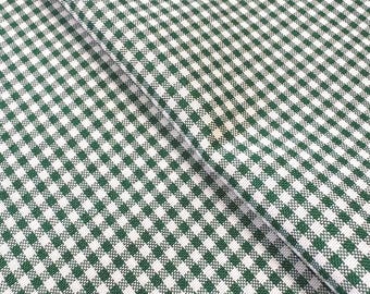 May include: Close-up of a green and white checkered fabric. The fabric is folded diagonally, creating a textured pattern of small squares. The color scheme is a classic combination, suitable for various craft and home decor projects.