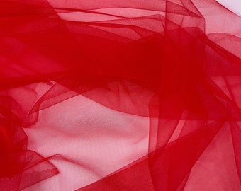 May include: Red tulle fabric with a soft, delicate texture. The fabric is sheer and lightweight, with a slightly shimmery finish.