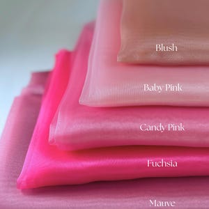 May include: A stack of sheer fabric in shades of pink, from light to dark. The colors are labeled: Blush, Baby Pink, Candy Pink, Fuchsia, and Mauve. The fabric has a soft, flowing appearance.