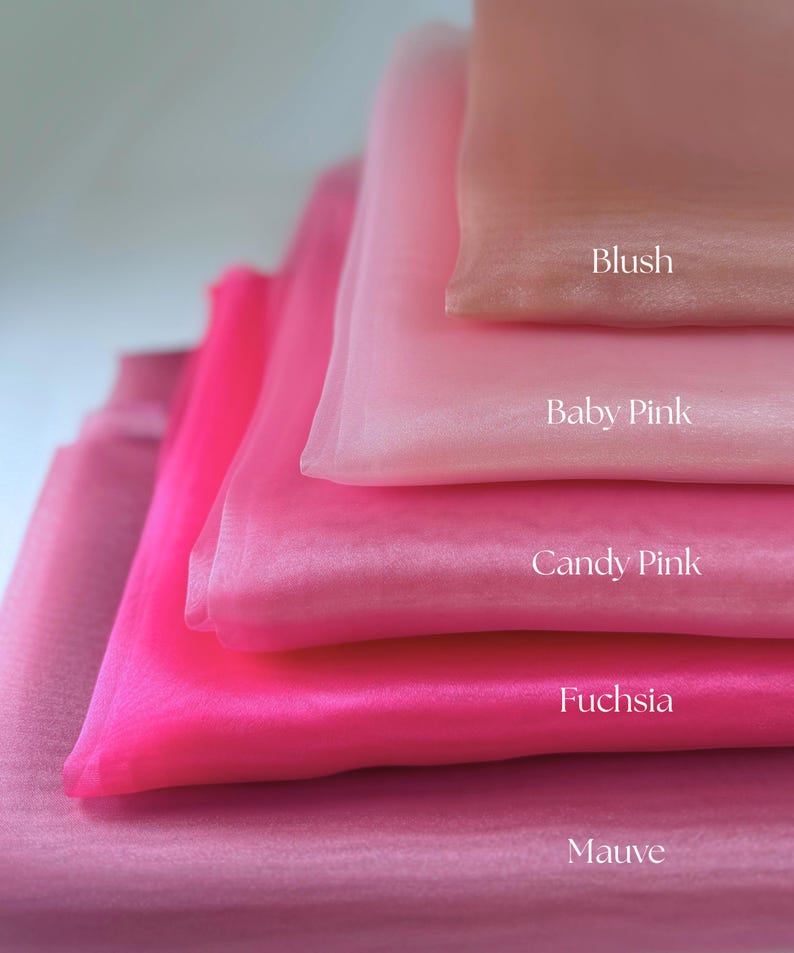 May include: A stack of sheer fabric in shades of pink, from light to dark. The colors are labeled: Blush, Baby Pink, Candy Pink, Fuchsia, and Mauve. The fabric has a soft, flowing appearance.