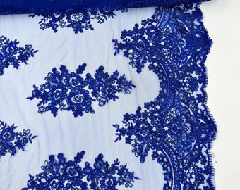 Puede incluir: Tela de encaje azul real con un diseño floral y lentejuelas. El encaje es delicado e intrincado, y las lentejuelas añaden un toque de brillo.