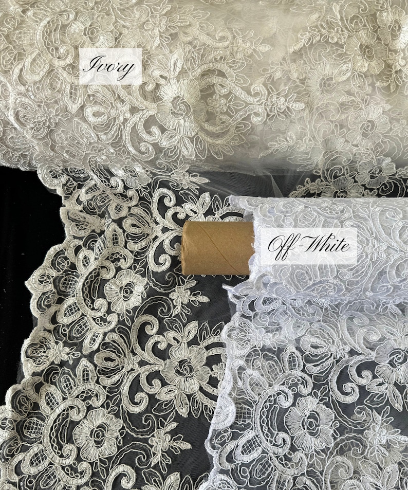 May include: Two rolls of white lace fabric with a floral pattern. The top roll is labeled "Ivory" and the bottom roll is labeled "Off-White".