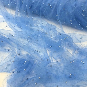 May include: Light blue tulle fabric with scattered silver beads. The fabric is sheer and delicate, with a soft, flowing texture.