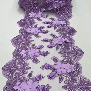May include: Purple lace fabric with 3D flower embellishments. The fabric has a delicate mesh base with sequins and small beads.