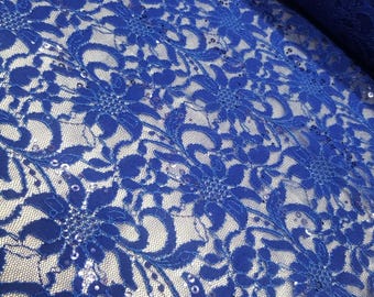 Puede incluir: Tela de encaje azul real con un patrón floral y lentejuelas dispersas.