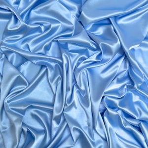 May include: A smooth, light blue satin fabric with soft folds and wrinkles.