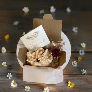 Coffret de demande en mariage romantique pour demoiselle d'honneur avec roses séchées, accents dorés et chouchou en satin. Seras-tu ma boîte de demande en mariage pour demoiselle d'honneur ?