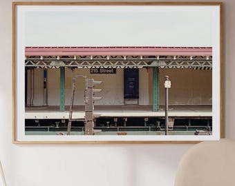 May include: A framed photograph of a subway station, with a red roof, green supports, and the text "77th Street". The photograph is displayed above a wooden table and three cream-coloured chairs.